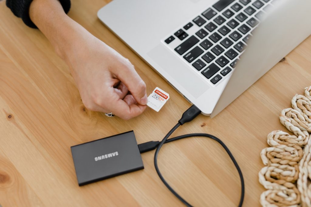 Person inserting memory card into laptop